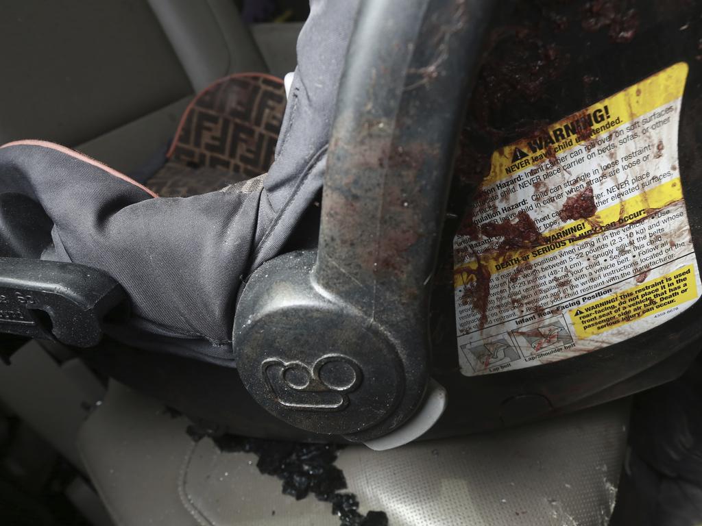 An infant's car seat stained with blood inside a bullet-riddled vehicle. Picture: Christian Chavez/AP