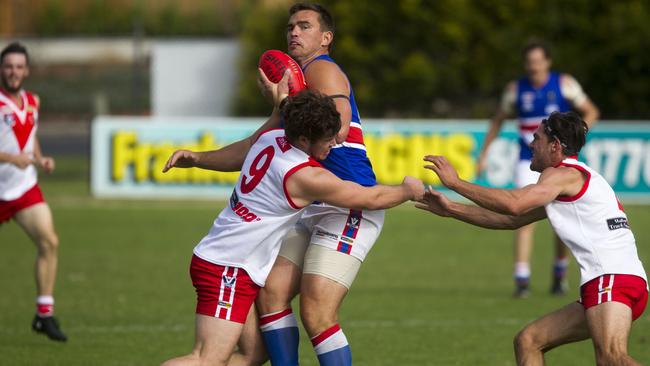 Karingal’s Jake Kelly (No. 9) and Damian Ashcroft tackle Mornngton’s Mick Gay this season. Picture: Richard Serong