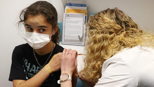 Tara Breusch, 12, gets jabbed with the Moderna vaccine in a Queensland pharmacy. Picture: Liam Kidston