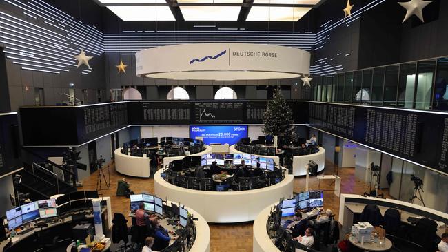 Traders work in front of a chart displaying Germany's share index DAX at the stock exchange in Frankfurt. Picture: Daniel Roland/AFP