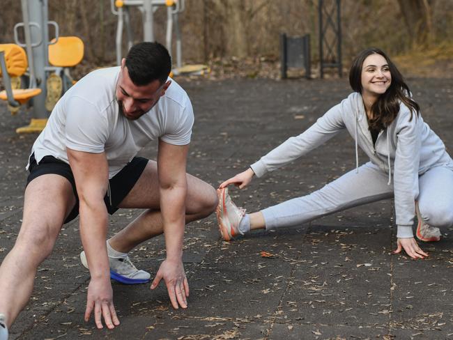 Joyful Couple Warming Up With Stretching Before Morning Workout