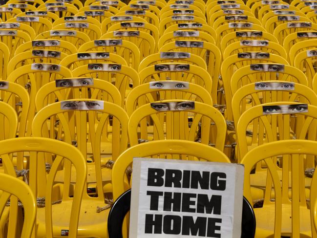 Stickers of eyes adorn chairs in a July 5 art installation in Tel Aviv calling for a hostage deal. Photo: Getty Images.