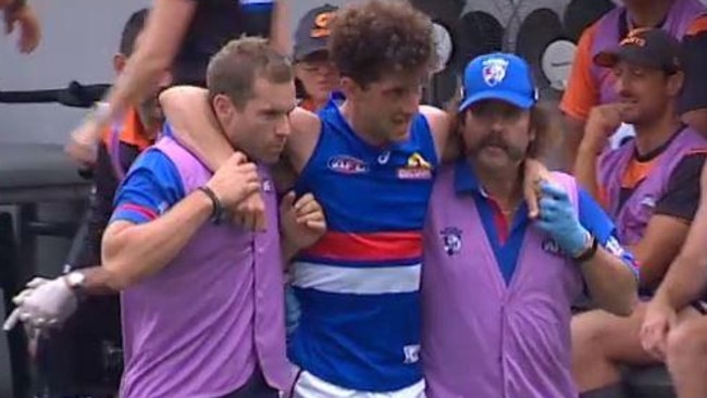 Tom Liberatore is helped from the ground after injuring his knee.