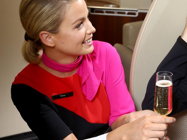 Launch of the new Martin Grant designed Qantas First Class Pyjamas. Will Lehnertz in PJs get a glass of Bubbly from Cabin Crew Fiona Hughes. Picture Chris Pavlich