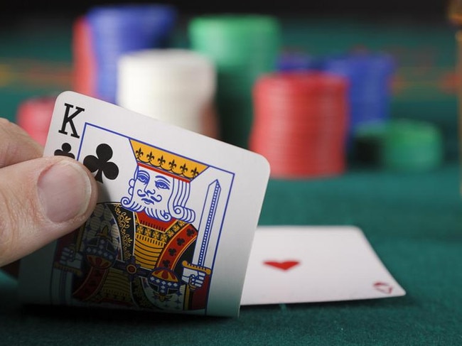 A close-up of a player's hand in a card game of blackjack.