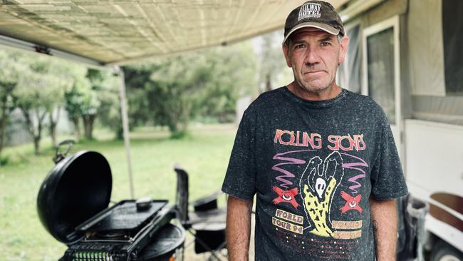 Adam McLarty near his camper at the front of his house in Murchison where he has been living since the flood. Picture: Adam Daunt