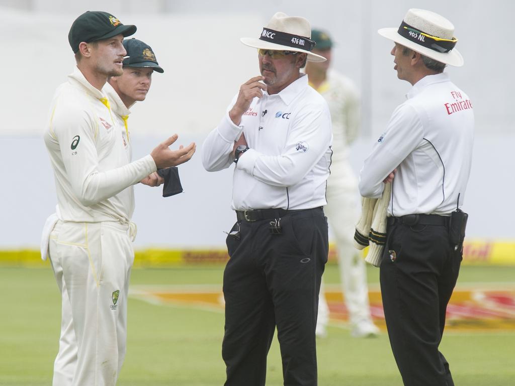 Umpires Nigel Llong and Richard Illingworth speaking with Cameron Bancroft.