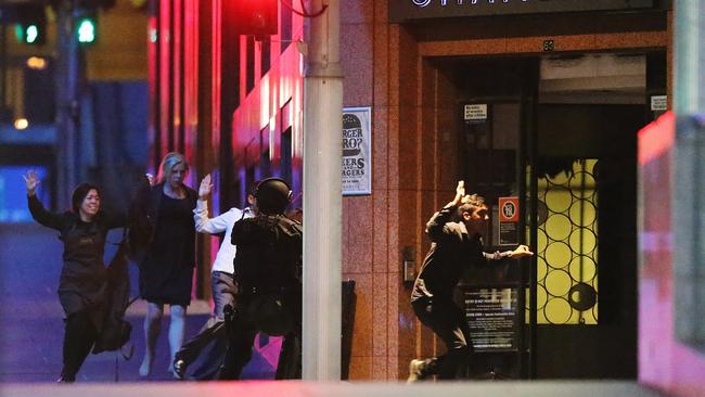 Hostages run toward police with their hands up during the siege.