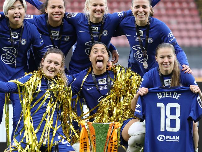 WATFORD, ENGLAND - MARCH 14: Ji So-Yun , Drew Spence , Pernille Harder , Melanie Leupolz , Erin Cuthbert , Sam Kerr and Fran Kirby of Chelsea pose for a photograph with the trophy as they hold up a shirt for Maren Mjelde of Chelsea who was seriously injured during the FA Women's Continental Tyres League Cup Final match between Bristol City Women and Chelsea Women at Vicarage Road on March 14, 2021 in Watford, England. Sporting stadiums around the UK remain under strict restrictions due to the Coronavirus Pandemic as Government social distancing laws prohibit fans inside venues resulting in games being played behind closed doors. (Photo by Naomi Baker/Getty Images)