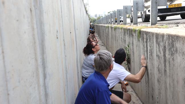 People leave their vehicles to take cover during a rocket attack from the Palestinian Gaza Strip along a main road in Tel Aviv. Picture: AFP