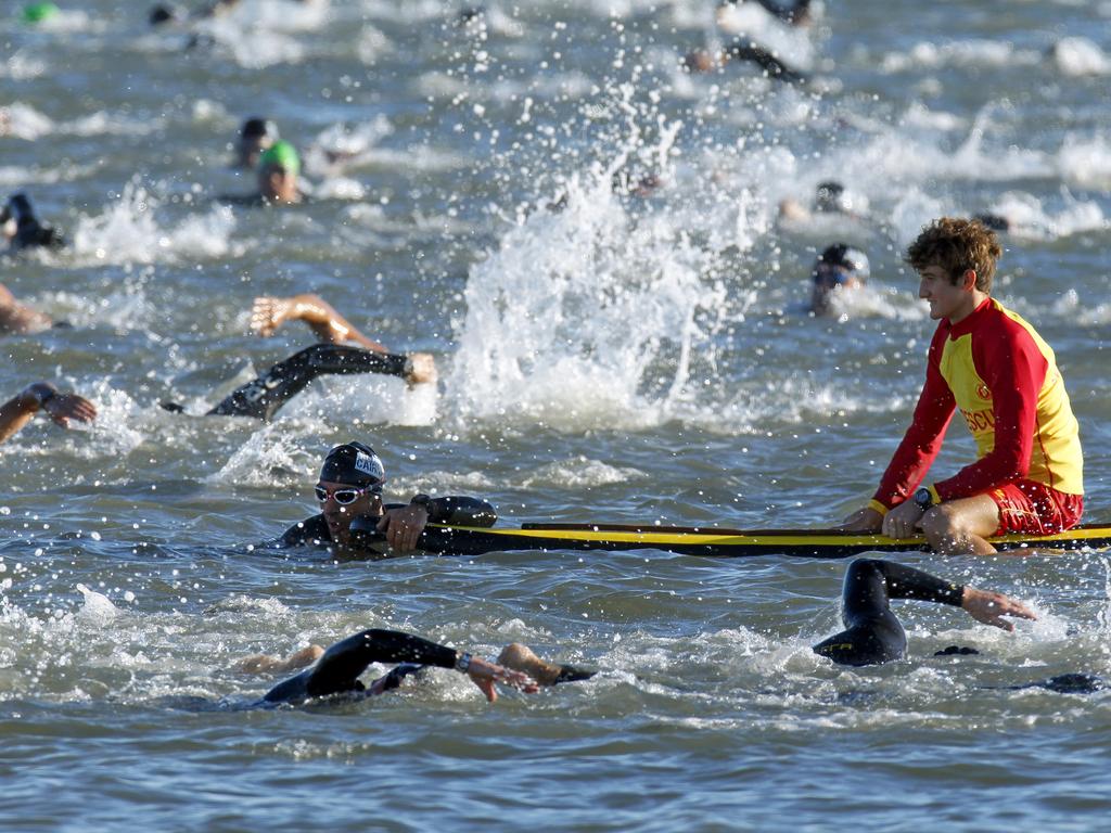 Cairns Ironman, swim leg. A competitor gasps for air on the board of a lifeguard during the swim.