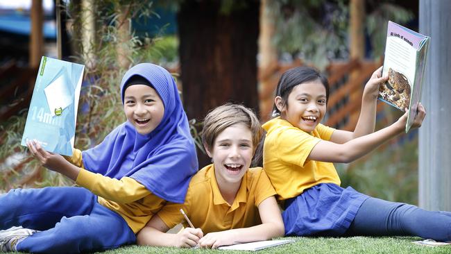 Moreland Primary School students Nafisa, 9, Orpheus, 9, and Serena, 8 celebrate improving their school’s NAPLAN results. Picture: David Caird