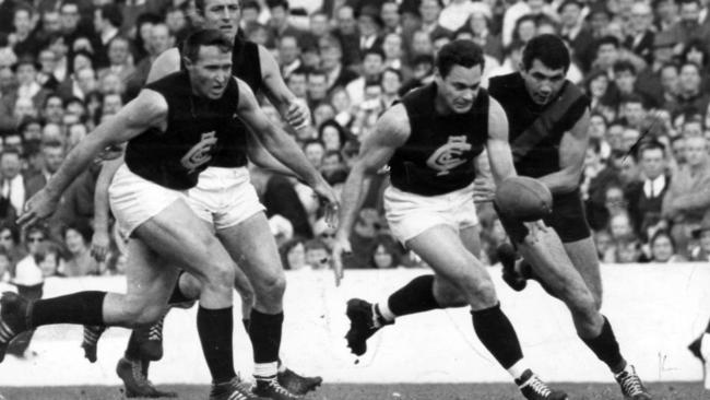 Carlton v Essendon in 1968. John Nicholls and Wes Lofts look on as Geoff Gosper pursues Ron Barassi.