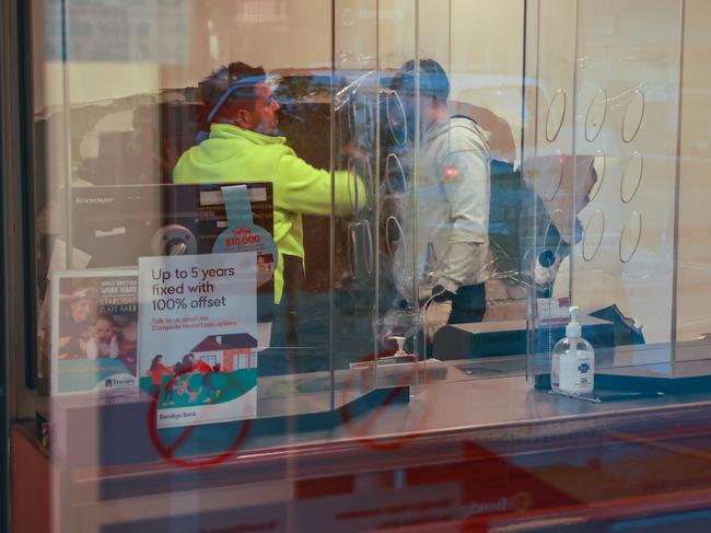 Workmen patching the wall at The Bendigo Bank, on Forest Road, Bexley, after it had a hole punched through it by demolition machinery working on a building site next door, today. Picture: Justin Lloyd