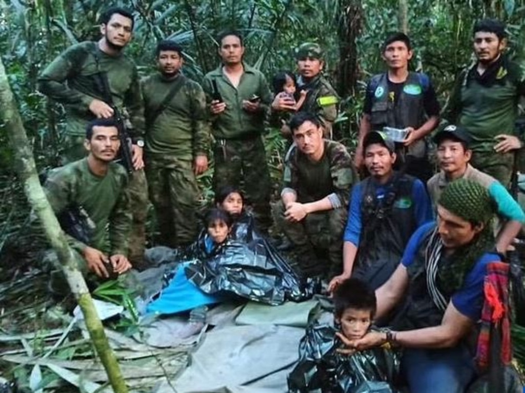 The Colombian Army pose with four indigenous children after spending more than a month lost in the Amazon rainforest following a small plane crash. Picture: AFP