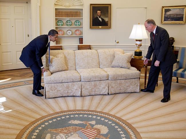 President Barack Obama is helped by Vermont Governor Jim Douglas to move a couch in the Oval Office on February 2, 2009. Governor Douglas met with the President about the economic recovery plan. Picture: Pete Souza/The White House