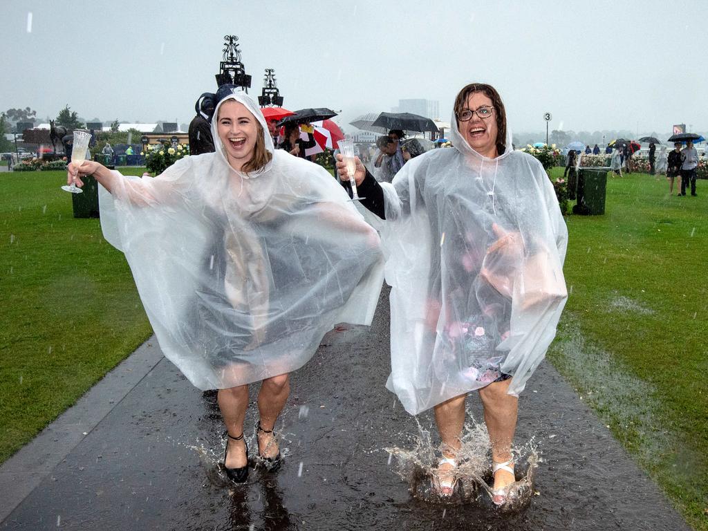 Ponchos were a sellout as heavy rain hit Flemington. Picture: Jason Edwards