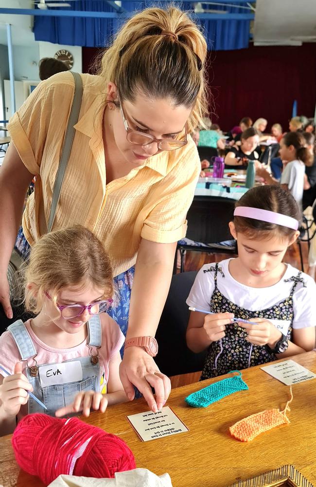 Sophie McClennan watches as daughters Eva and Willow knit samplers. Picture: Contributed