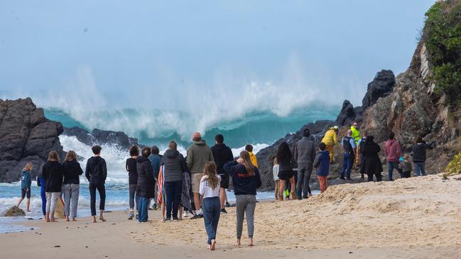 Crowds wait on the beach after the man’s body was airlifted to the shore. Picture: Shane Chaulker