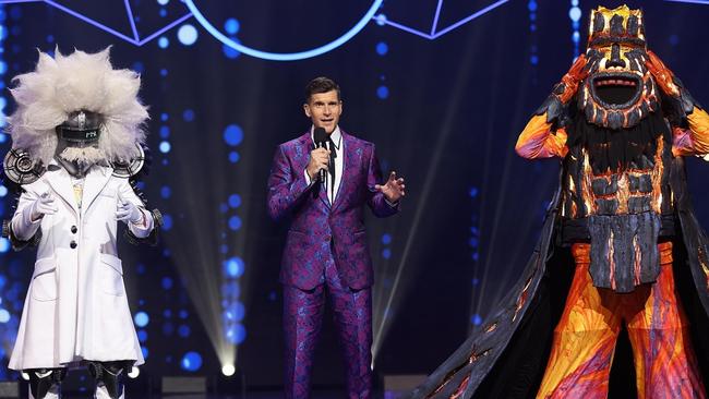 Host Osher Gunsberg with two of the contestants in stunning costumes again designed by the Academy award-winning designer Tim Chappel. Picture: Nigel Wright