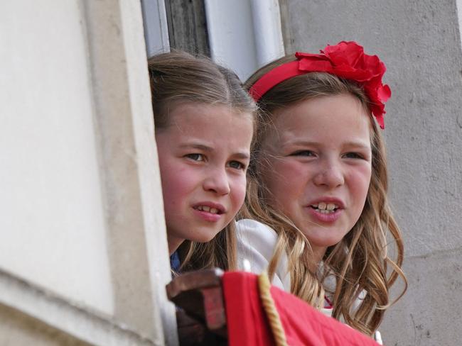 Princess Charlotte and Mia Grace Tindall watch from a window of Buckingham Palace. Picture: Yui Mok/Pool/AFP