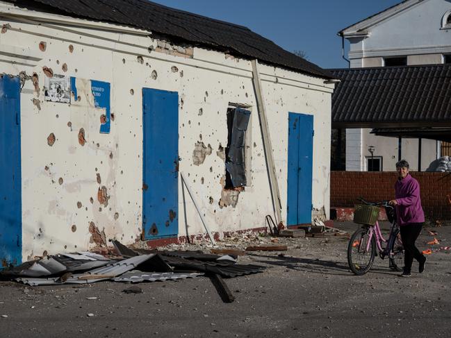 A woman walks past a building damaged in Kozacha Lopan after 30 per cent of the country's power stations were destroyed in Russian attacks. Picture: Carl Court/Getty Images