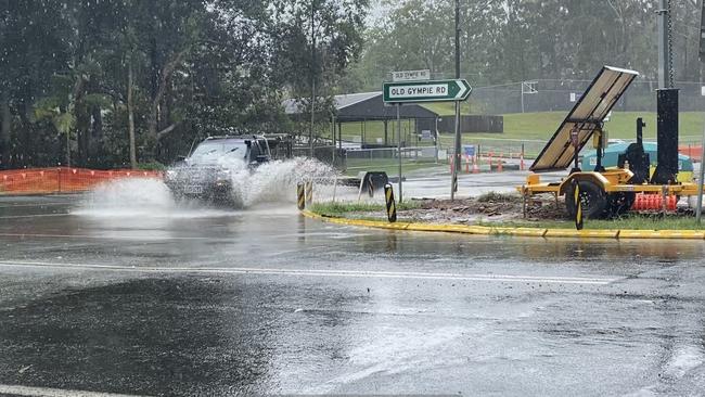 Motorists driving through the rain at the corner of Old Gympie Rd and Kilcoy Beerwah Rd. Photo: Natalie Wynne