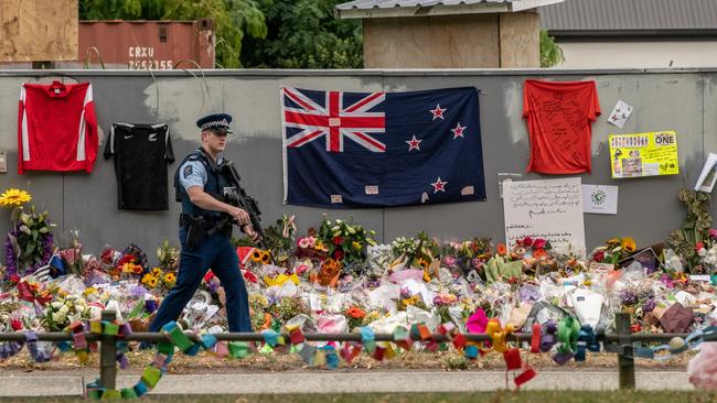 An armed police officer passes flowers and tributes near Al Noor mosque in Christchurch, New Zealand. Picture: Carl Court/Getty Images