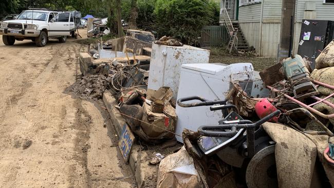 Flood-damaged goods are piled on Railway St in South Murwillumbah. Picture: Liana Walker