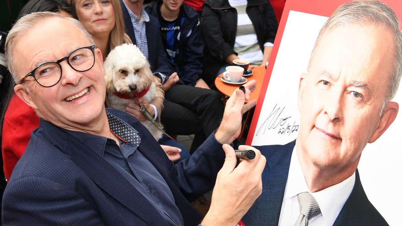 Prime Minister-elect Anthony Albanese signs a poster for a young boy as he shares a coffee near his home today. Picture: James D Morgan/Getty Images