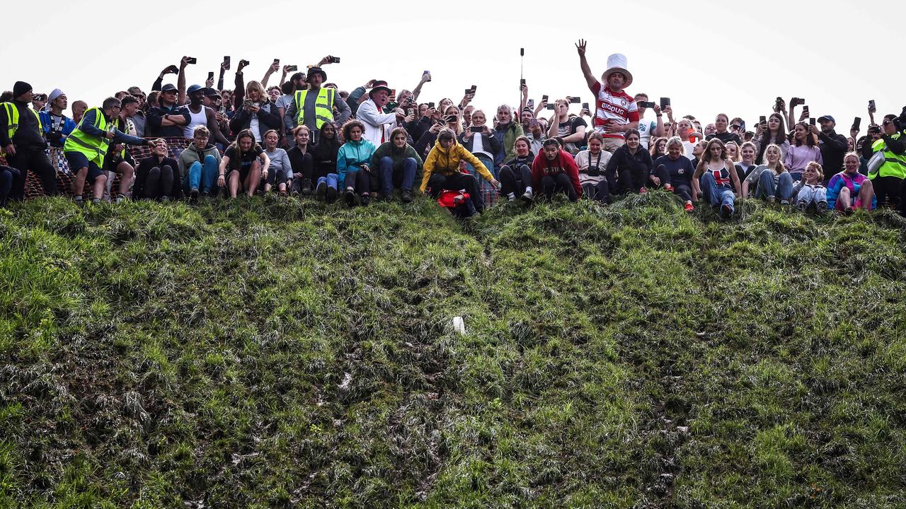 The event in Gloucester, UK, was thought to have started around 1826. That small white blob is the cheese wheel being thrown at the start of the women’s race. Picture: Henry Nicholls/AFP