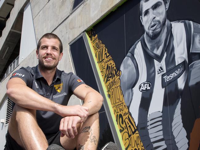 Hawthorn skipper Ben Stratton with a mural of him painted on the side of the old grandstand at Waverly .       . Pic: Michael Klein