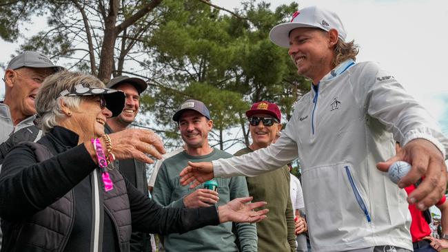 Cam Smith hugs spectator Annette Blake after his wayward tee shot on the 17th hole hit her. (Photo by Asanka Ratnayake/Getty Images)