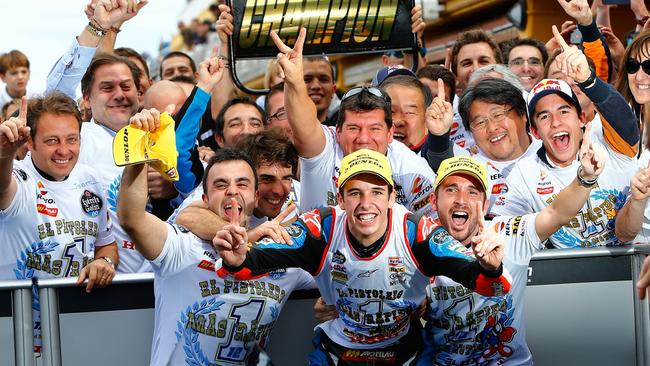 Marquez celebrates victory with his team, brother Marc (R) and manager Emilio Alzamora (L).