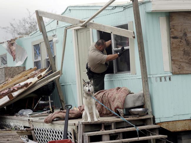 An official climbs through a window as he checks a home damaged by Hurricane Harvey on Sunday. Picture: Eric Gay/AP