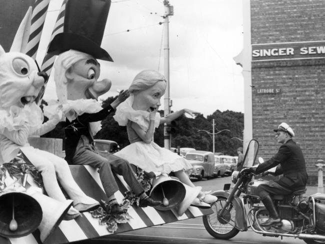 A police escort travels with an Alice in Wonderland float at the city’s 1955 Christmas parade.