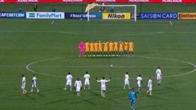 Screen grab showing the Australian team observing silence while Saudi players warm up before the match.