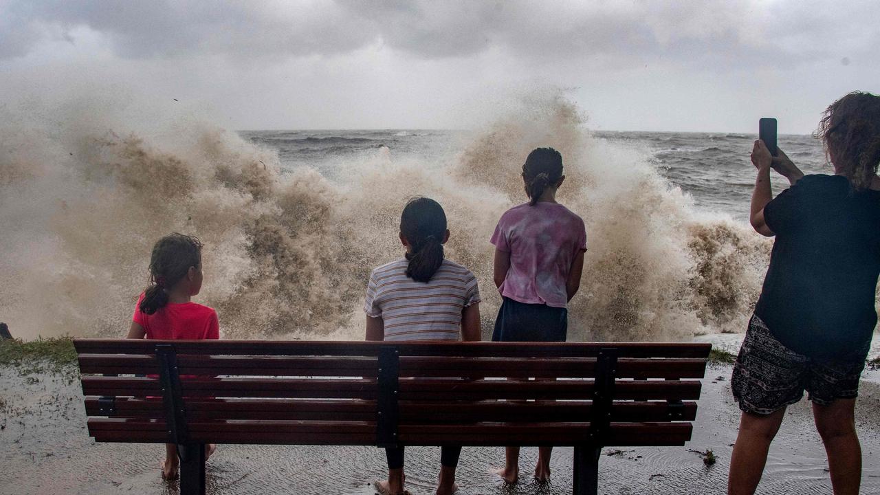 A family watch the storm roll in across the Coral Sea at Holloways Beach as Cyclone Jasper approaches landfall in Cairns. Picture: Brian Cassey