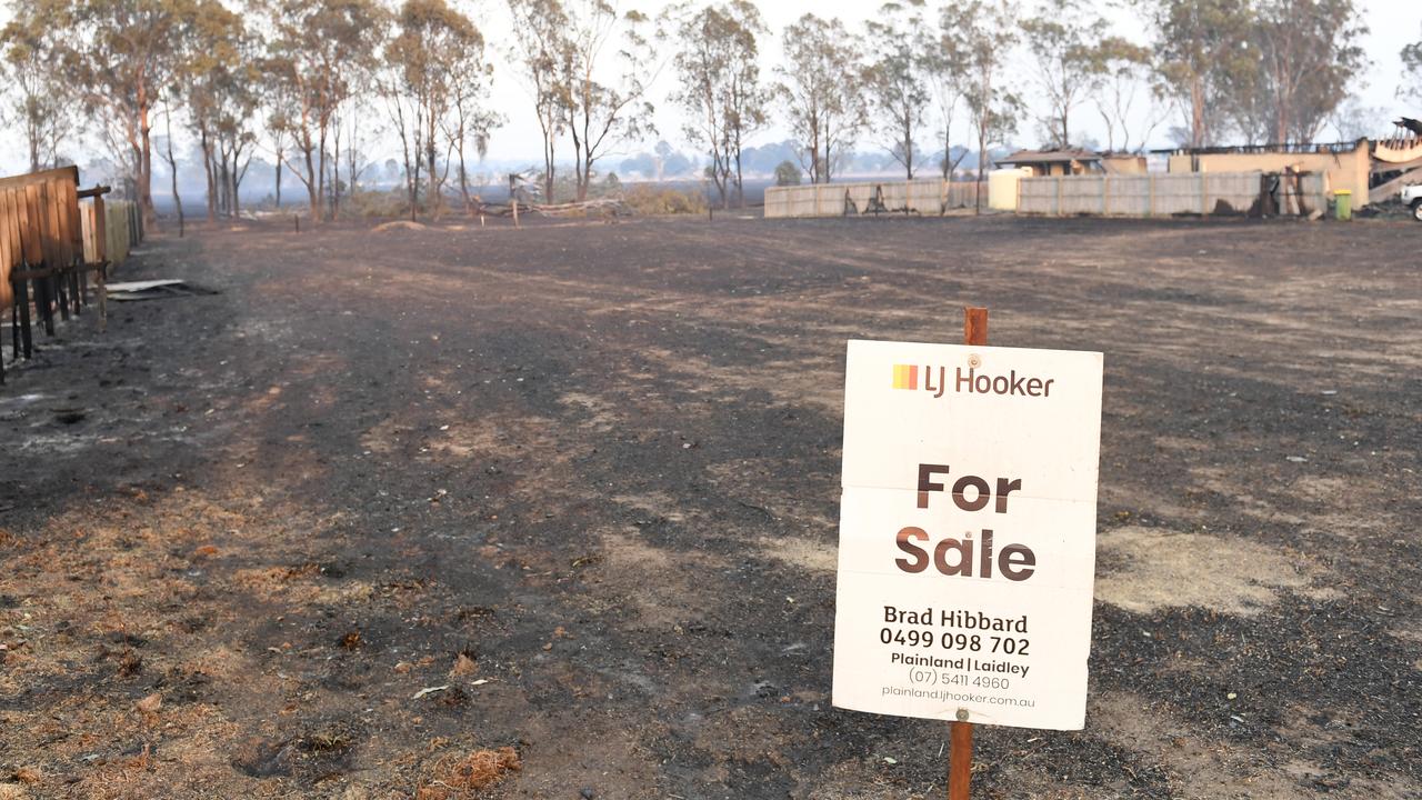 A for sale sign is seen on vacant land next to a house that was burnt down by bush fires in Laidley. (AAP Image/Scott Davis)