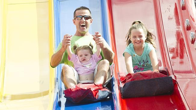 Almost 250,000 people whizzed down the Super Slide, including Warren Bell and his daughters Taylor, 8, and a slightly nervous-looking Alex, 2. Picture: Melvyn Knipe