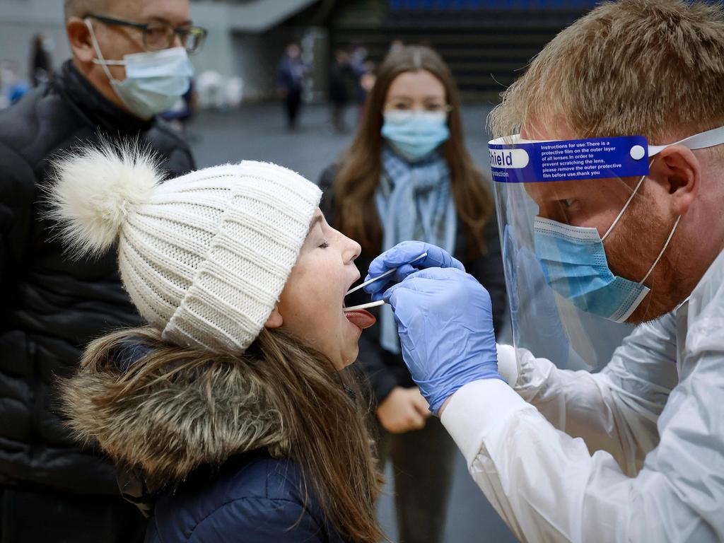 A child opens her mouth as she is being tested for coronavirus COVID-19 during a mass testing in the Arena Nord in Frederikshavn, in Northern Jutland, Denmark, on November 7, 2020. - All citizens in seven municipalities of North Jutland (Hjoerring, Frederikshavn, Broenderslev, Jammerbugt, Vesthimmerland, Thisted and Laesoe) are under special restrictions until December 3, 2020, as a mutated version of the new coronavirus linked to mink farms was found in humans. (Photo by Claus Bjoern Larsen / Ritzau Scanpix / AFP) / Denmark OUT