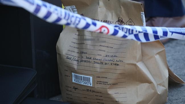 Police collect evidence at the scene including a stained bedsheet. Picture: David Swift