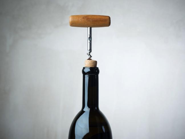 Corkscrew and wine bottle, opening a bottle of wine in celebration