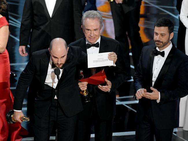 'La La Land' producer Jordan Horowitz holds up the winner card reading actual Best Picture winner 'Moonlight' with actor Warren Beatty and host Jimmy Kimmel onstage. Picture: Getty