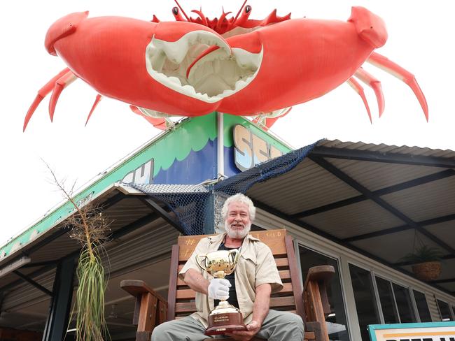 Theo Molloy holding the 18-carat-gold Lexus Melbourne Cup trophy in Cardwell, Queensland, as part of its 2024 tour. Picture: Lucas Dawson