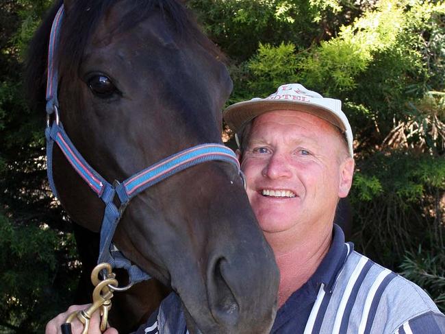 Trainer Kym Davison with racehorse Overture at his stables in Albury.