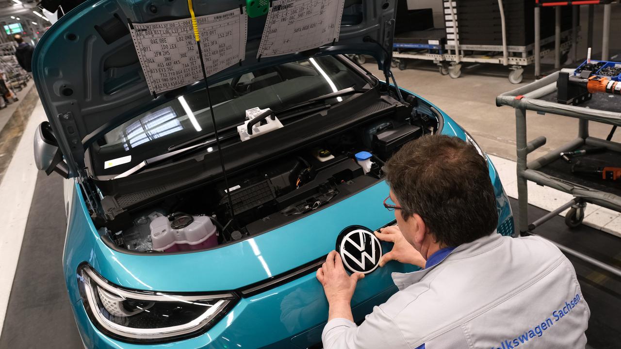 A worker attaches the VW hood ornament onto an ID. 3 electric car on the assembly line at the Volkswagen factory. Picture by Sean Gallup/Getty Images