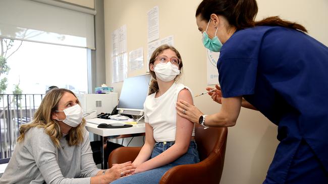 Lizzy Barber Rodger gets some reassurance from mother Claire Barber as doctor Jill Gamberg prepares her vaccination in Double Bay on Monday. Picture: Jane Dempster
