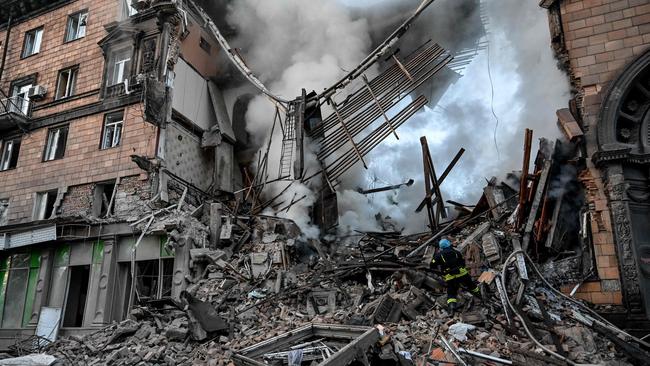 A Ukrainian firefighter pushes out a fire after a strike in Zaporizhzhia.