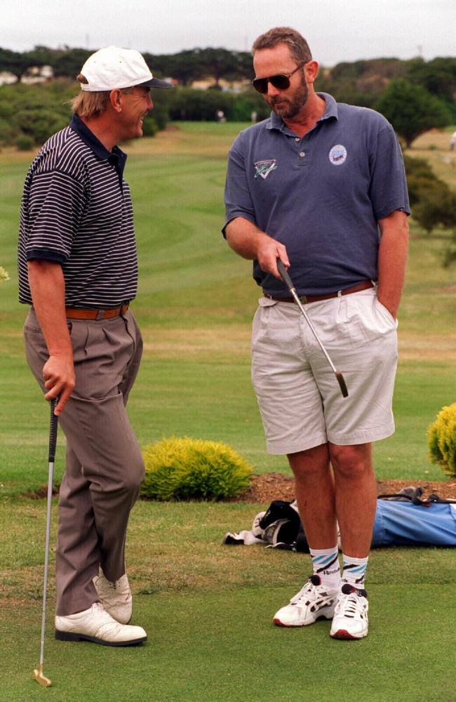 Walls playing golf with Malcolm Blight in 1995.